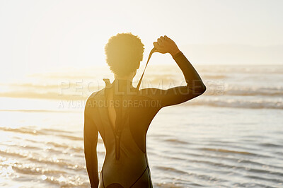 Buy stock photo Zip, swimsuit and surfer dressing to surf at the beach, sea and ocean waves during sunset or sunrise on holiday. Back view, surfing and person relax on vacation enjoying sports, exercise or workout 