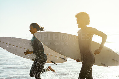Buy stock photo Sunset, beach and couple running in the water with surfboards to practice surfing while on vacation. Nature, sports and young man and woman surfers in the ocean while on a tropical holiday in Hawaii.