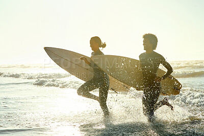 Buy stock photo Sunset, running and couple in the ocean water with surfboards to practice surfing while on vacation. Nature, sports and young man and woman surfers in the sea while on a beach holiday in Hawaii.
