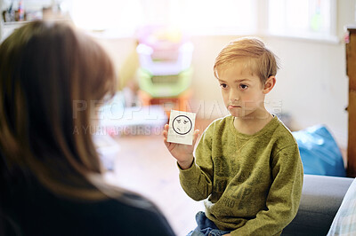Buy stock photo Therapy, emotion and boy talking to a therapist while sitting on a sofa in a psychology clinic. Discussion, flash card and child psychologist helping a kid with his feelings, adhd and mental health.