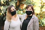 Portrait, happy and nature with woman friends or sisters standing outdoor together with a covid face mask. Smile, love and family with mature female siblings bonding in a garden to relax
