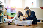 Covid, education or toys with a mother and son in a playroom together for learning or child development. Children, family or school with a woman teaching motor skills to a student boy during lockdown