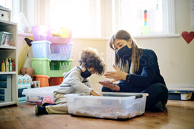 Buy stock photo Covid, education or toys with a mother and son in a playroom together for learning or child development. Children, family or school with a woman teaching motor skills to a student boy during lockdown