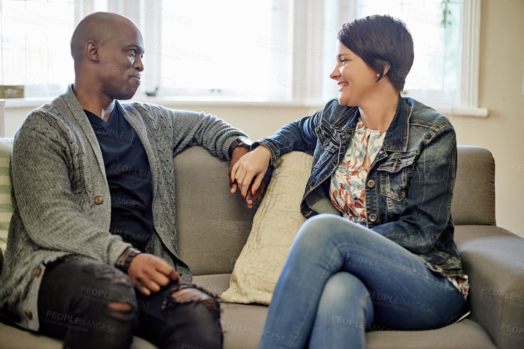 Buy stock photo Therapy, counseling and couple on sofa happy and talking in session for consulting, support and marriage. Psychology, interracial and black man and woman in conversation, discussion and communication