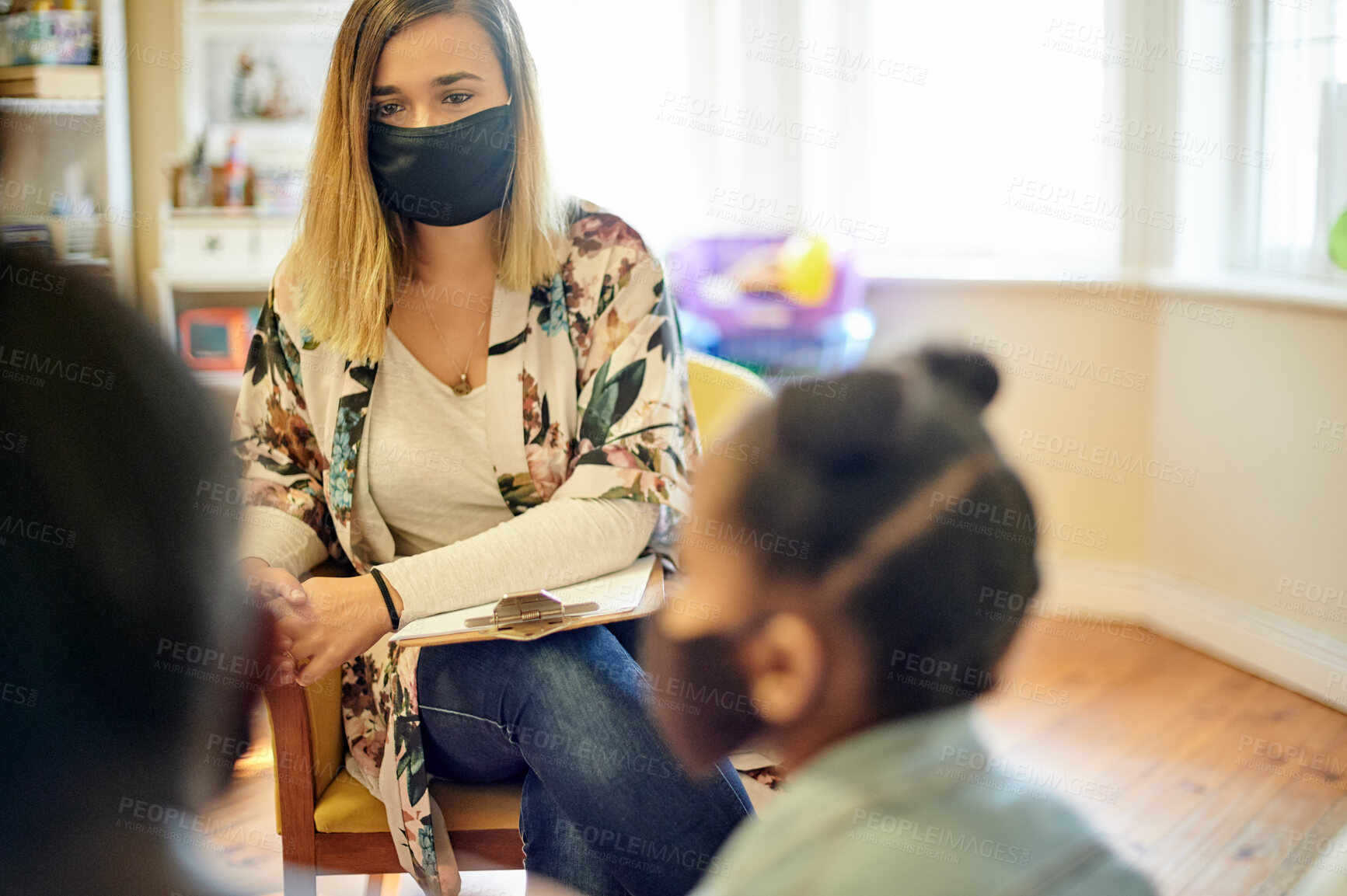 Buy stock photo Psychologist, mother and child in consultation during covid for help, mental health and support. Face mask, therapist and woman talking with black girl and mama for counselling, therapy or advice.