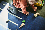 Learning, top view and kid play with toys, having fun and enjoying childhood in home. Development, growth and infant, child or baby toddler with shapes for playing and education in house on carpet.
