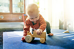 Learning, cute and toys with baby on floor of living room for child development, education and happiness. Curious, youth and  nursery with child with wooden car at home for playful, fun and games