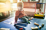 Education, toys and building blocks with baby on floor of living room for child development, learning and health. Curious, innocence and playing with kid at home for mobility, games and youth