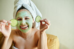 Facial, treatment and happy woman holding cucumber for vitamin c, wellness and natural beauty relaxing at home Face, mask and portrait of happy female using vegetable for a detox dermatology 