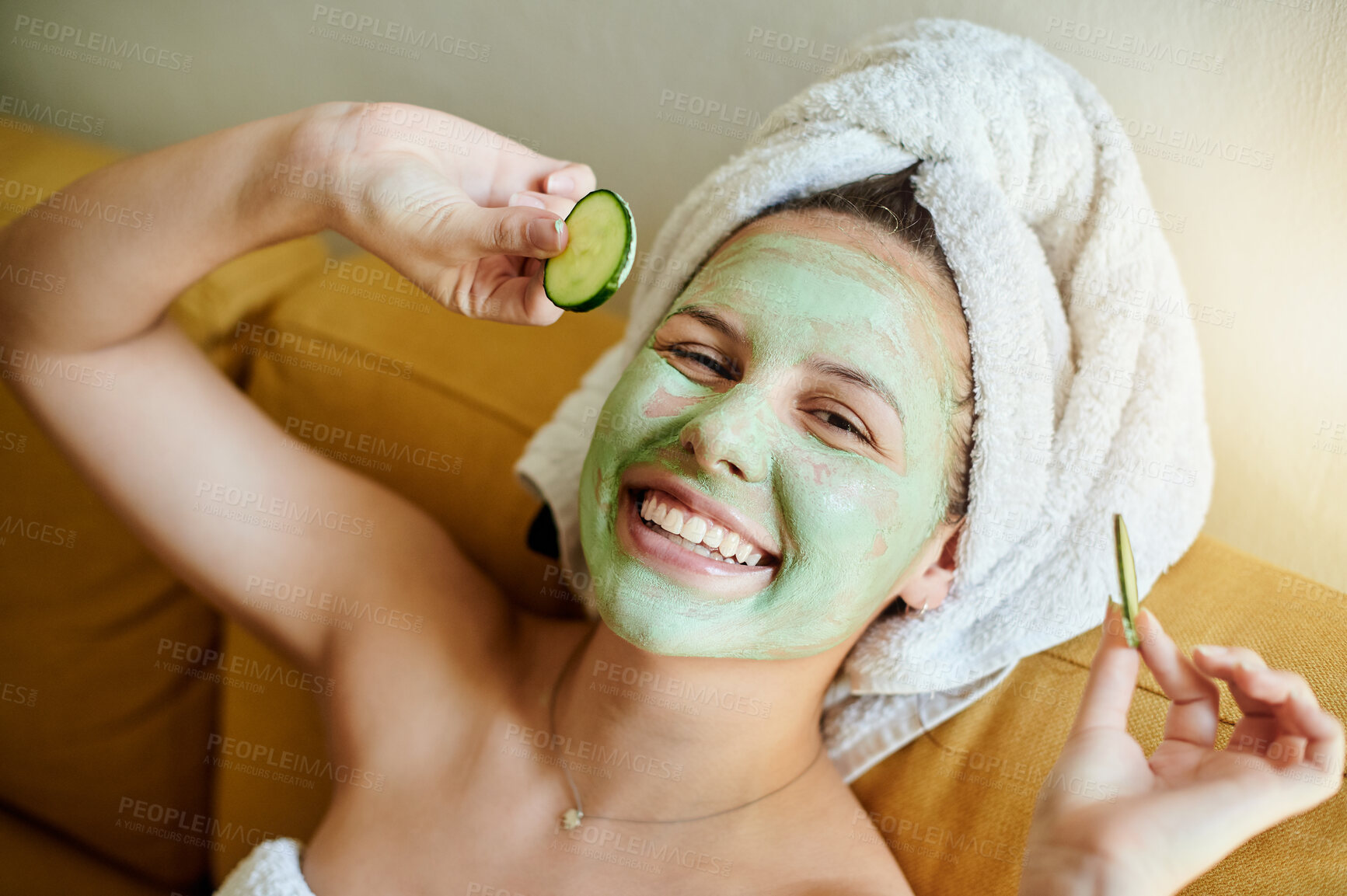 Buy stock photo Facial, treatment and portrait of happy woman with cucumber for vitamin c, wellness and natural beauty lying on a couch or sofa. Relax, spa and of female using skincare cosmetics or dermatology`