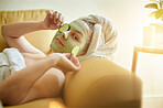 Spa, relax and portrait of woman with cucumber on an eye or face for vitamin c, wellness and natural beauty lying on a couch or sofa. Treatment, spa and skincare of female using vegetable to detox