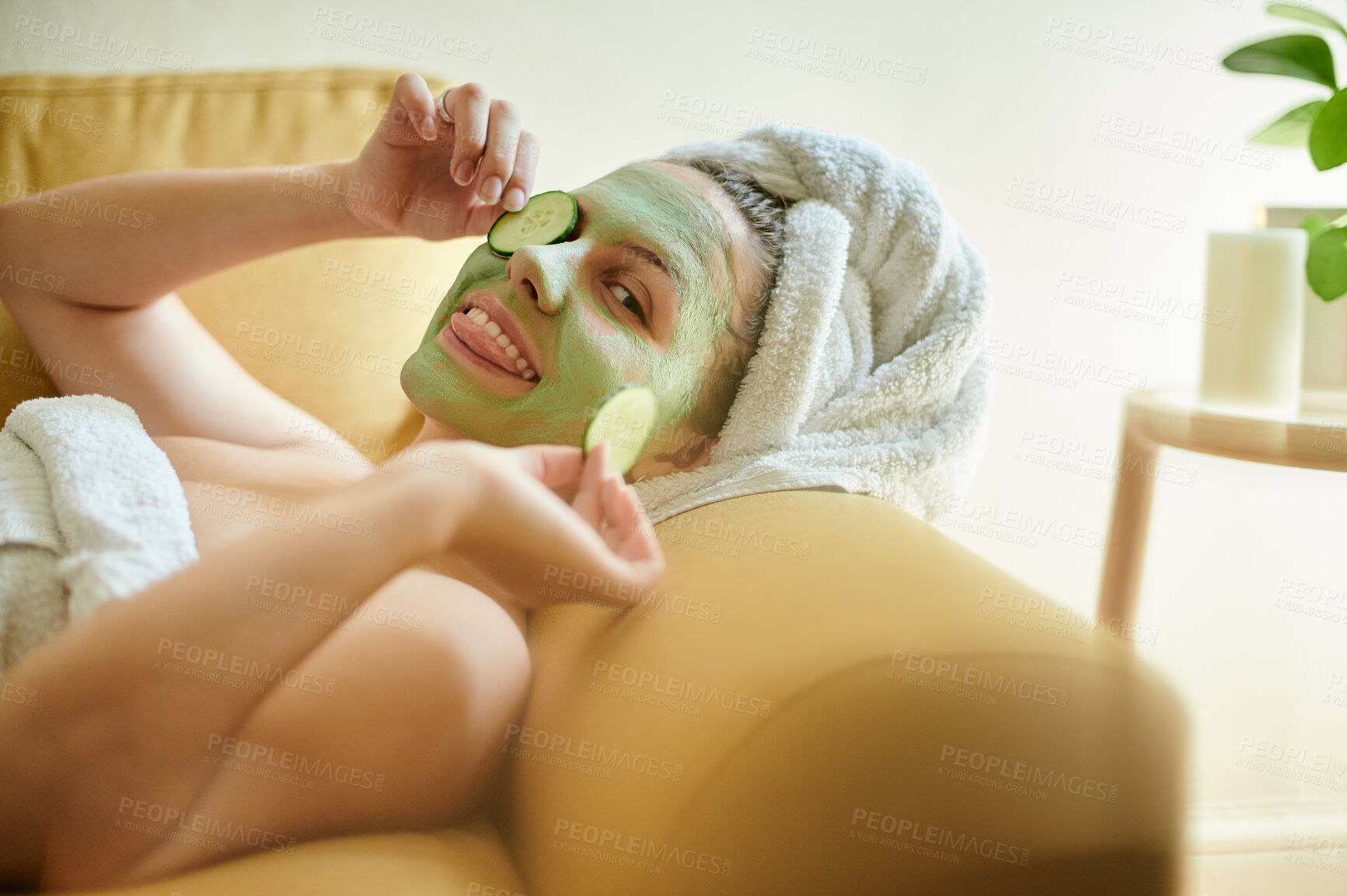 Buy stock photo Facial, spa and funny woman with cucumber on an eye or face for vitamin c, wellness and natural beauty lying on a couch. Relax, treatment and portrait of happy female in a detox with tongue out