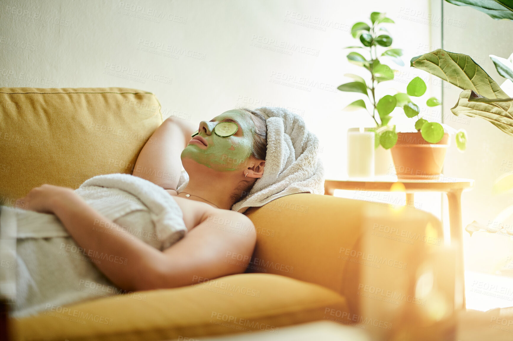 Buy stock photo Facial, treatment and woman with cucumber on eyes or face for vitamin c, wellness and natural beauty lying on a couch or sofa. Relax, spa and skincare of happy female using vegetable to detox