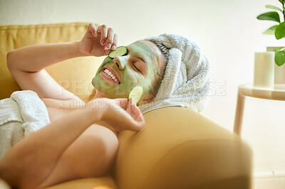 Buy stock photo Sofa, skincare and woman with face mask and cucumber on couch in lounge. Beauty, happiness and person with facial treatment for dermatology, healthy or glowing, flawless skin or natural cosmetics.