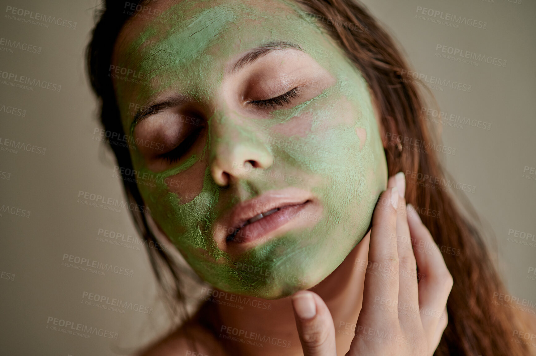 Buy stock photo Facial, treatment and woman using beauty product on her face for cosmetics, skincare and self care in a studio background. Detox, mask and female cleaning her skin for morning routine while she relax