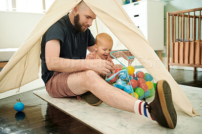 Buy stock photo Father, baby and playing with toys in family home or bedroom with a tent and color balls on floor. Man and happy boy, child or kid together to play for growth development, learning and quality time
