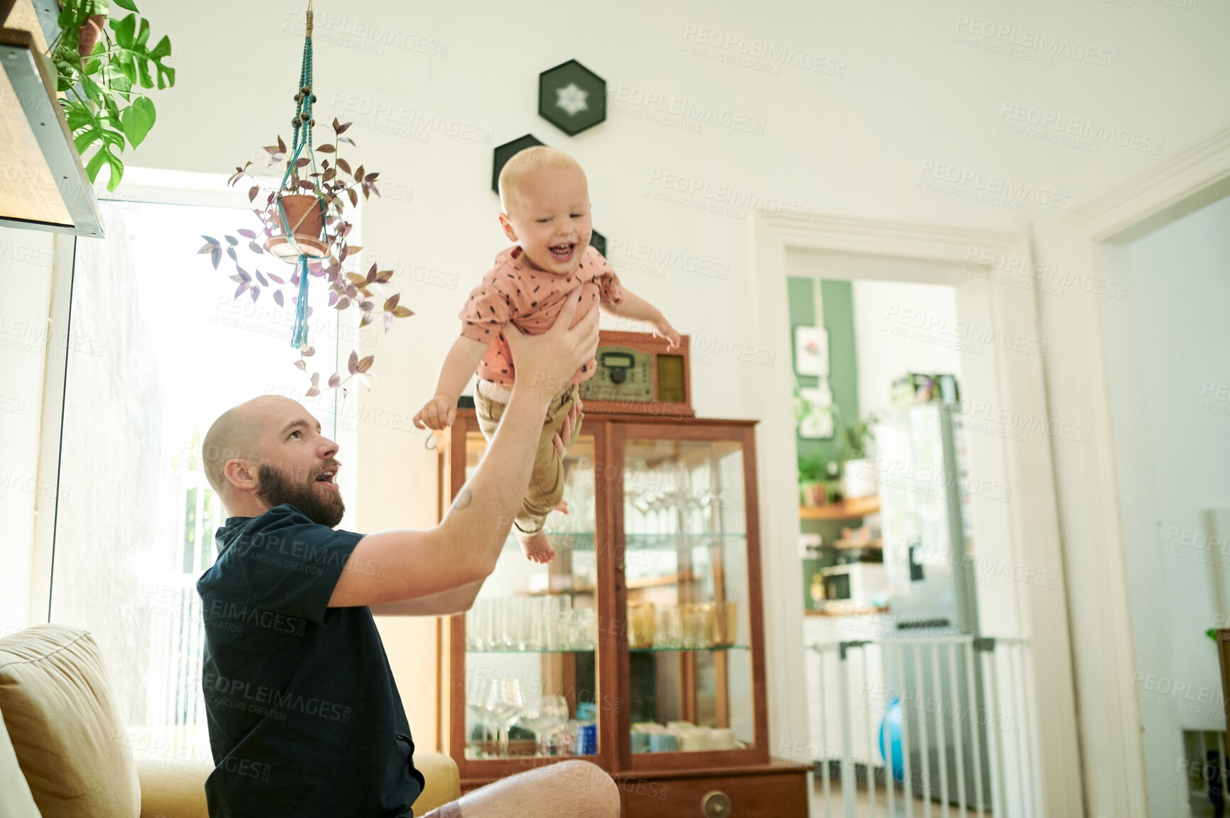 Buy stock photo Baby, father and lifting child plane in air on the sofa in a family home living room for fun. Male person or dad with a toddler kid for quality time, love and happiness while playing game together