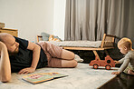 Toy truck, father and baby playing in a family home bedroom for fun, growth and development. Man or dad with toddler kid, book and toys for quality time, learning and together for quality time