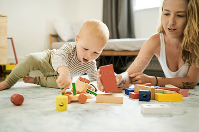 Buy stock photo Playing, baby toys and learning with blocks and a mother and child in family home bedroom for fun. Woman or mom with toddler kid together for quality time, building and mobility or growth development