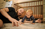 Family, children and a father playing with his baby son in the bedroom using a hand puppet for bonding. Kids, love and a young man having fun together with his infant child on the floor of their home