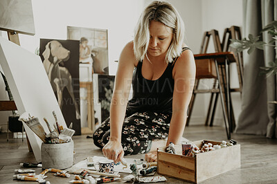 Buy stock photo Painter, studio and woman with canvas on floor with color for work, squeeze tube and creativity at house. Painting, female artist and workshop with palette for project, hobby and passion for artwork.