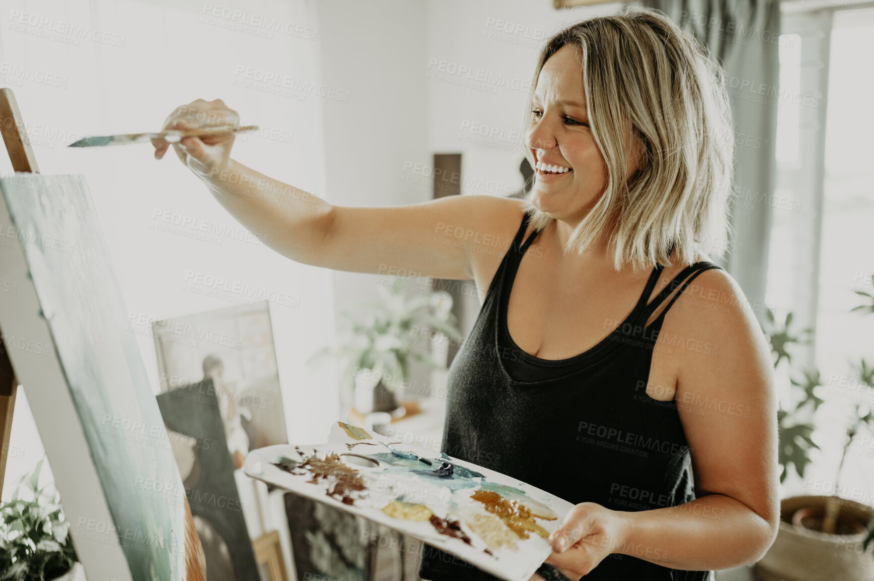 Buy stock photo Happy woman, painting in workshop with palette and canvas, creative person with talent and creativity. Art, female artist and brush with watercolor, easel and painter with craft, smile or inspiration