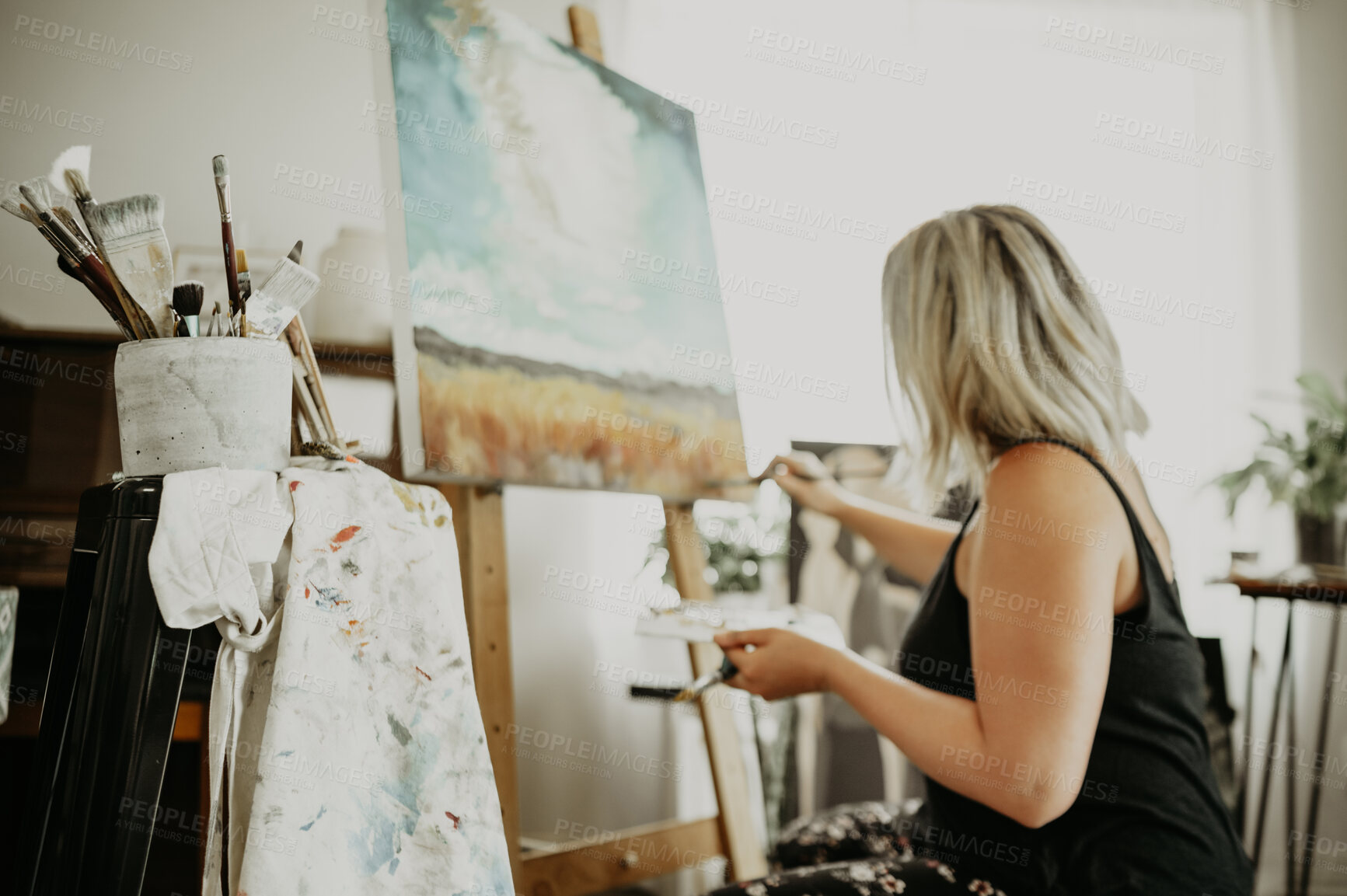 Buy stock photo Art, canvas on easel and painting, woman in studio at home with brush, creativity and inspiration with color. Paint, tools and talent, professional artist with ideas and freedom for creative work.