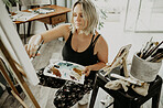 Woman, painting and creative art in studio, home or house with brush, paint and canvas. Artist person and relax painter with talent for design in workshop