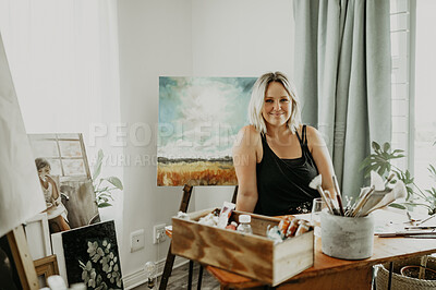 Buy stock photo Art, painting and portrait of woman in studio at desk for drawing, illustration and landscape creation. Home workshop, artist and happy female person with paintbrush, stationery and canvas for hobby