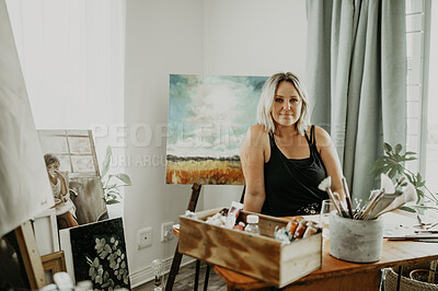 Buy stock photo Creative, painting and portrait of woman in studio at desk for drawing, illustration and artwork creation. Home workshop, artist and female person with paintbrush, stationery and canvas for hobby