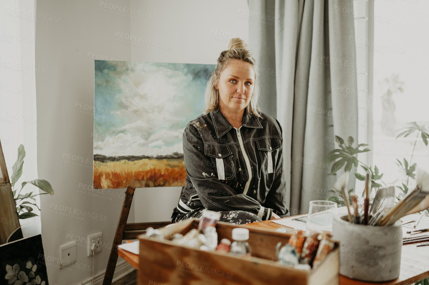 Buy stock photo Creative, landscape painting and portrait of woman in studio for drawing, illustration and artwork creation. Home, artist and female person with paintbrush, stationery and canvas for hobby at desk