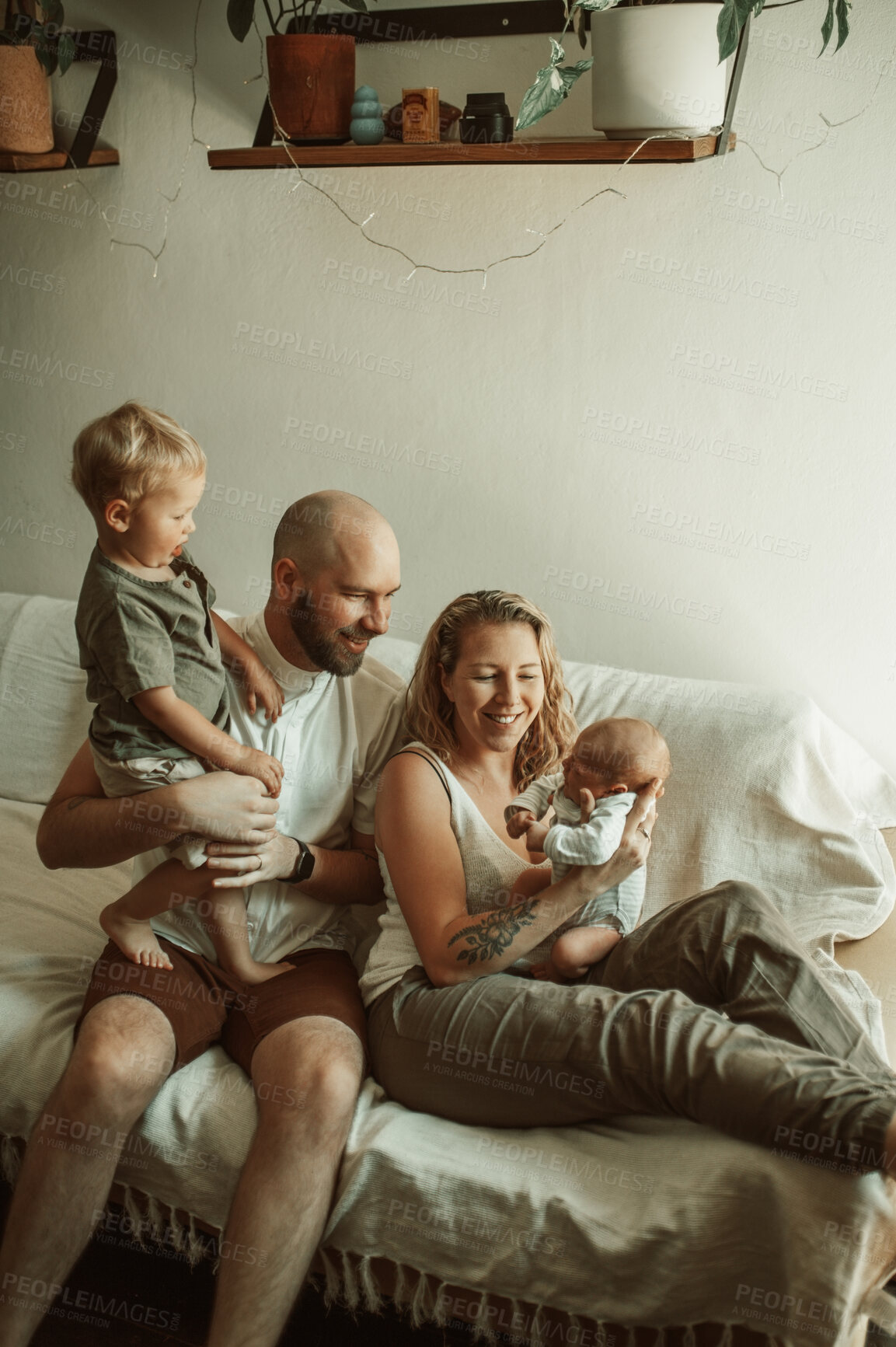 Buy stock photo Happy family, bond and parents with baby and toddler on sofa with smile, care and relax in their home together. Newborn, love and mother and father with children in a living room enjoying parenthood