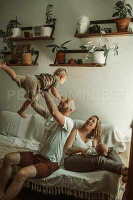 Buy stock photo Parents, kids and a family playing on the sofa in the living room of their home together for bonding. Mother, father and children in the house with a baby and cute boy child having fun in the lounge