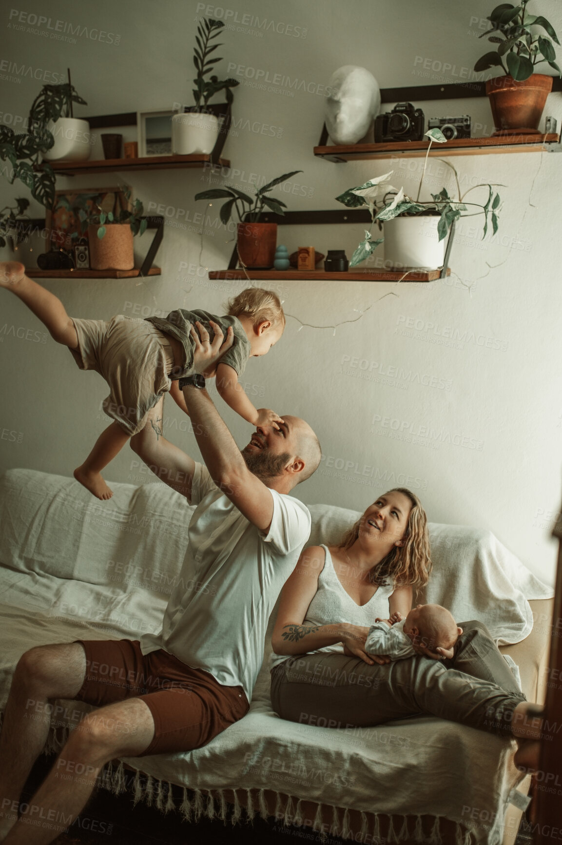 Buy stock photo Parents, kids and a family playing on the sofa in the living room of their home together for bonding. Mother, father and children in the house with a baby and cute boy child having fun in the lounge