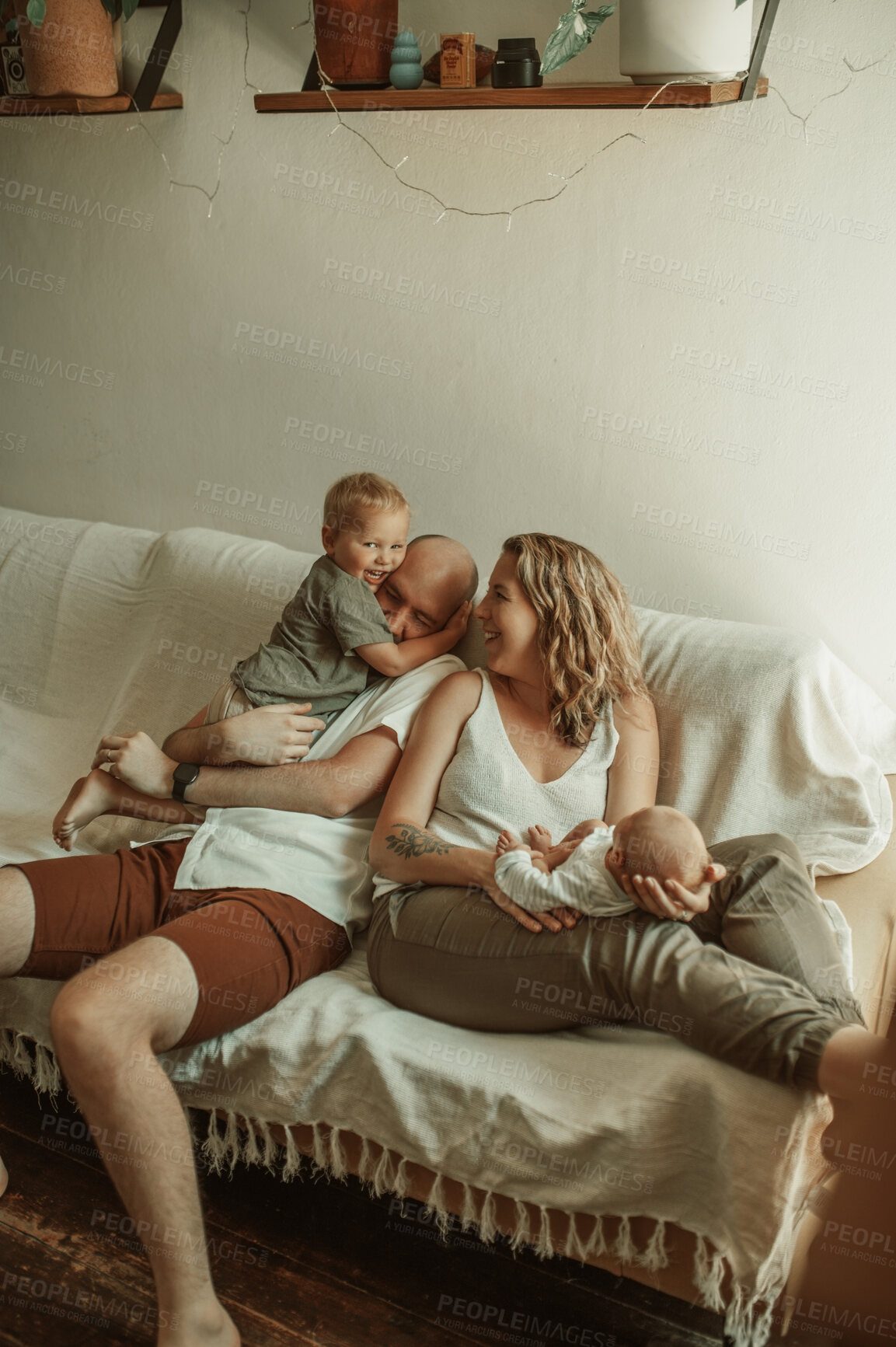 Buy stock photo Parents, kids and a family joking on the sofa in the living room of their home together for bonding. Mother, father and children in the house with a cute baby and playful boy child in the lounge