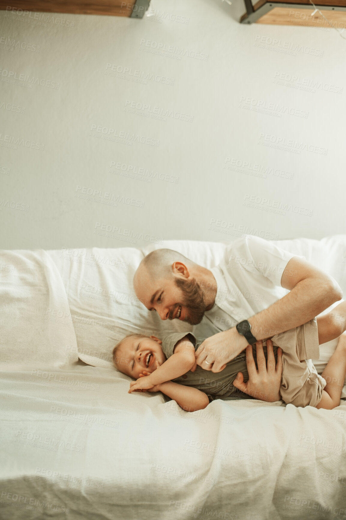 Buy stock photo Father, happy child and tickle in home for love, care and bonding together on sofa. Dad, boy and funny kid laughing, having fun or enjoy quality time in house living room playing with parent on couch