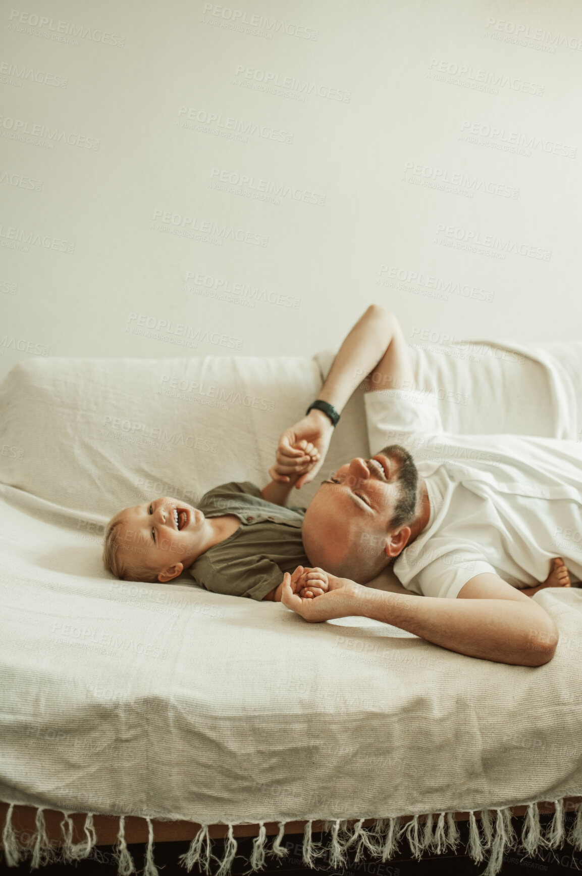 Buy stock photo Funny, father and son on a couch, humor and family with happiness, bonding and loving together. Male parent, happy boy or kid on a sofa, child development and laughing with joy, home and quality time