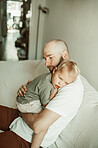 Dad, kid and hug in home for love, care and bonding together on sofa. Father, boy and child embrace for affection, enjoying quality time in house living room with parent on couch in lounge and relax.