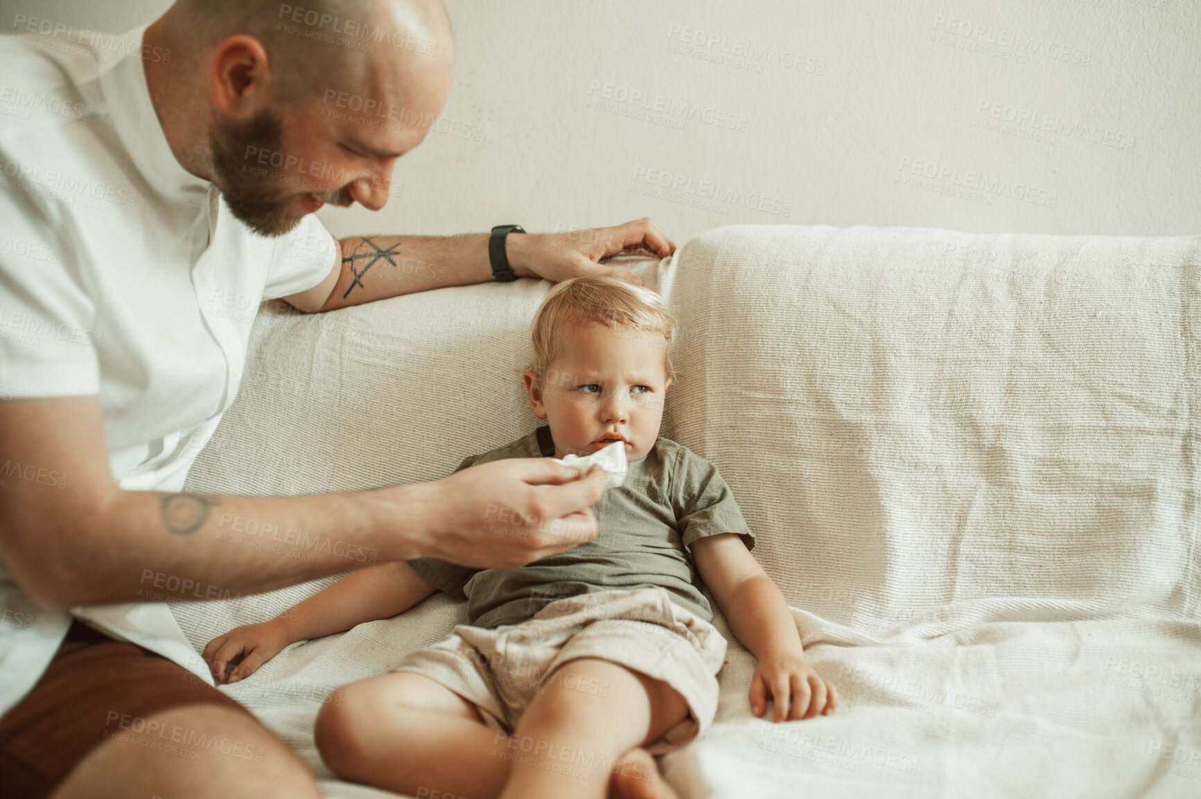 Buy stock photo Father, kid and wipe nose of sick child on sofa in home living room for family healthcare. Dad, boy and toddler with tissue for flu, allergies or cold, virus or disease, illness or covid in house.