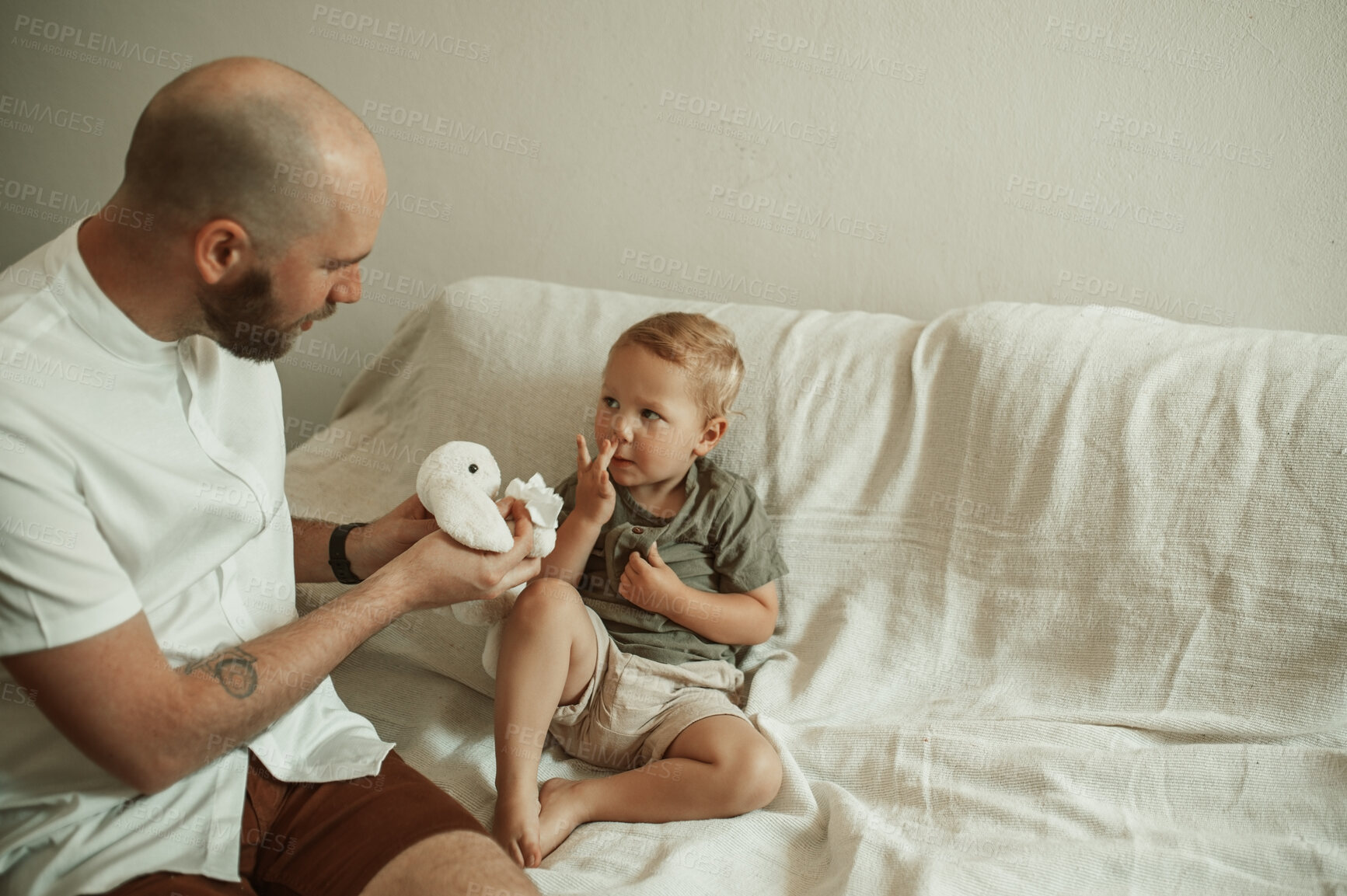 Buy stock photo Playing, father and child on a home sofa with a toy for bonding and weekend fun. Show, family and a playful young dad with toys and a boy kid on the couch for education, game or activity together