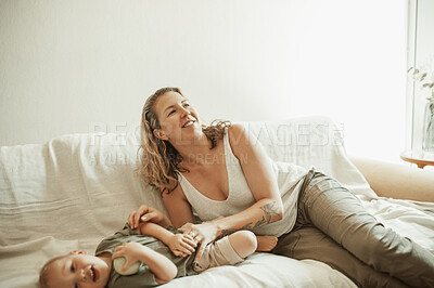 Buy stock photo Happy, playful and a mother and baby on the sofa for bonding, care and love in a home lounge. Smile, laughing and a mom playing with a little child or toddler on the living room couch on the weekend