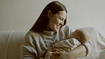 Happy, care and mother with her baby on a sofa for relaxing, bonding and resting in living room. Smile, love and young mom holding her infant, newborn or child with happiness in lounge of family home