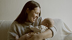 Happy, love and mother with her newborn on a sofa for relaxing, bonding and resting in living room. Smile, care and young mom holding her infant, baby or child with happiness in lounge of family home