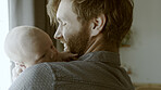 Happy, hug or father with baby in home for care or bond together to nurture child development. Smile, newborn or single parent dad with infant for support, trust or comfort in family house to relax