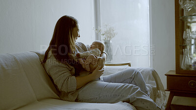 Buy stock photo Smile, love and mom with her newborn on a sofa for relaxing, bonding and resting in living room. Happy, care and young mother holding her infant, baby or child with happiness in lounge of family home