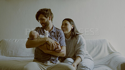 Buy stock photo Mom, dad and baby on a sofa in the living room of their home together for love, care or bonding. Family, smile and relax with happy young parents holding their cute newborn infant chid in a house