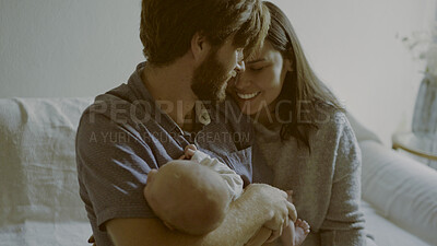 Buy stock photo Mother, father and baby on a sofa for love in the living room of their home together while bonding in care. Family, smile and relax with young parents holding a cute newborn infant chid in the house
