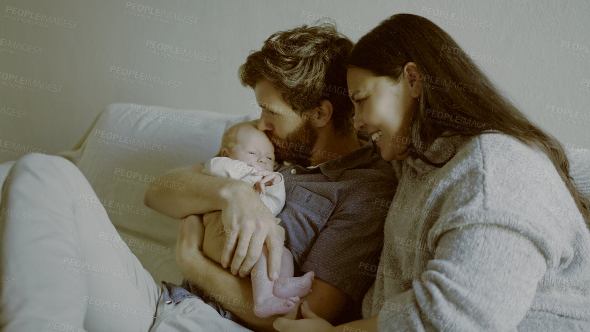 Buy stock photo Kiss, mother or father with a newborn in a happy family to relax or bond together for child development. Smile, parents or proud dad with mom or baby infant for love, safety or trust on sofa in home 