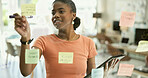 Woman, smile or sticky note on glass board, office or brainstorming with creative plan for project management. Young worker, idea or happy by scrum post on wall, strategy or productivity in workplace