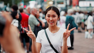 Buy stock photo Tourist, woman and peace sign with photography in city for travel memory, sightseeing and profile picture update. Japanese person, smile and hand gesture for holiday adventure and vacation location